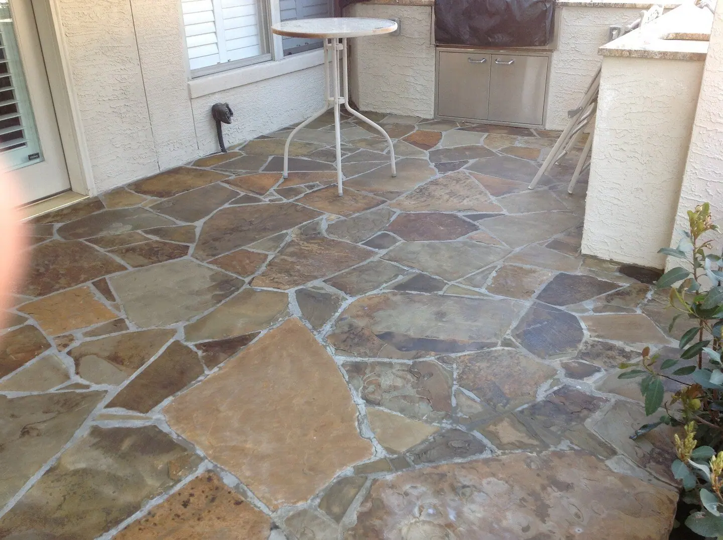 Flagstone patio with a small table by an outdoor kitchen